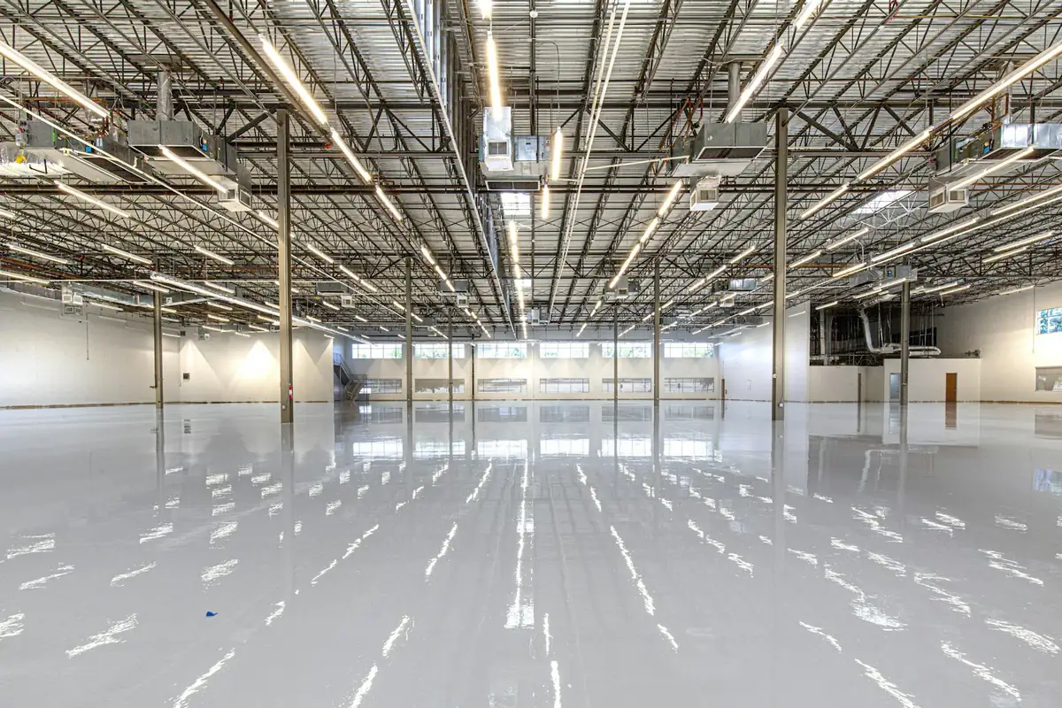 Glossy grey epoxy coating across a large commercial floor